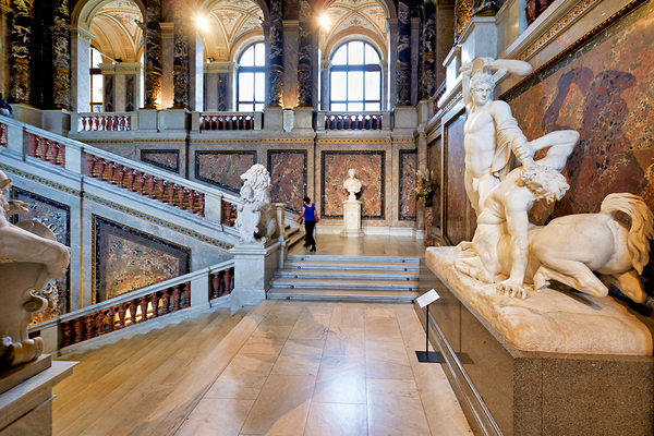 Ornate museum hall with statues grand staircase and visitor. Print