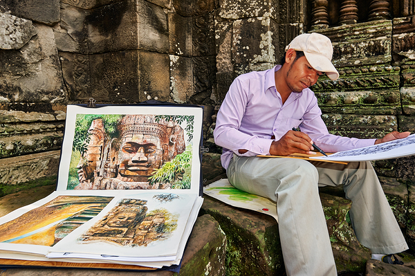 Artist drawing ancient temple carvings outdoors. Print