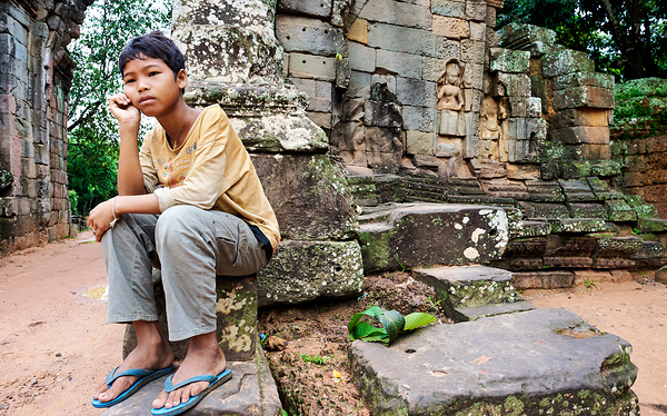 Young person sits on ancient temple ruins. Print
