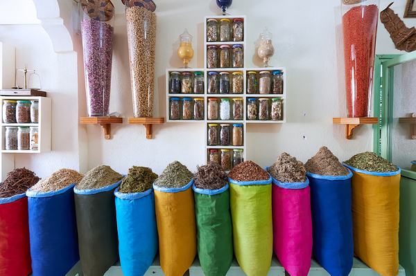 Herbal remedy shop in Marrakesh showing colorful bags of herbs Print