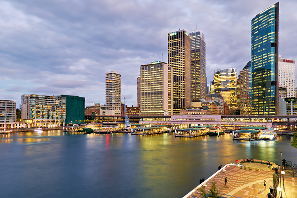 Sydney Harbour at dusk with ferries and city skyline. Print