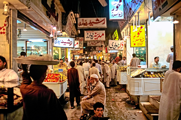 Night market in Lahore filled with vendors and shoppers by Marco Brivio