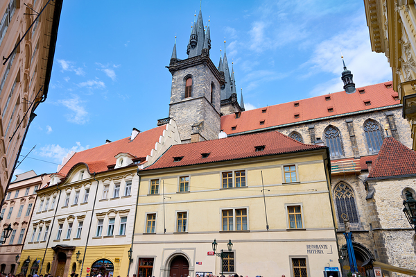 Pragues Týn Church and historic buildings under blue sky. Print