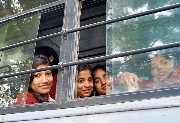 Girls traveling on a bus in Delhi India during daytime by Marco Brivio