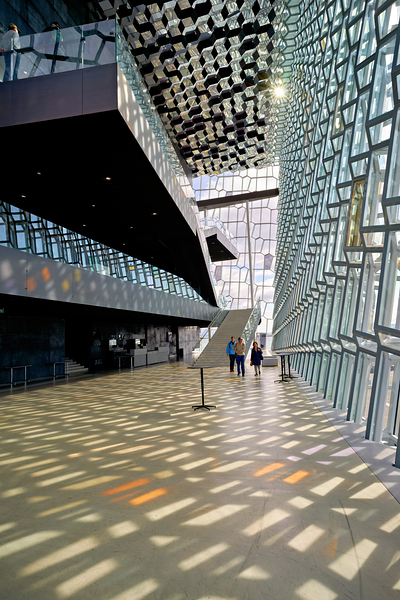 Visitors walk through Harpa Opera House in Reykjavik Iceland by Marco Brivio
