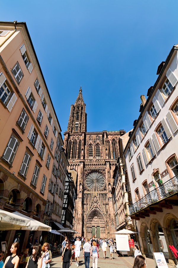 Visitors stroll by the Cathedral in sunny Strasbourg  Imprimer