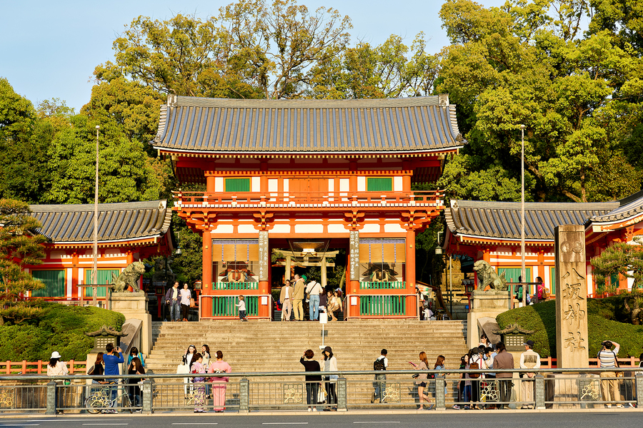 Kyoto Yasaka shrine temple with visitors and trees in background  Print