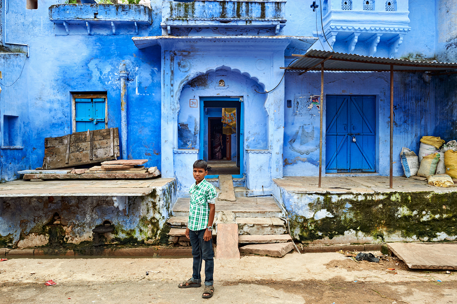 Decorated painted house in Bundi with a boy standing outside  Print
