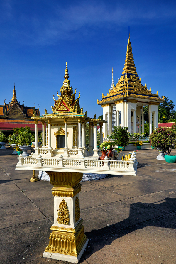Golden shrine and temple buildings in Cambodia under blue sky.  Print
