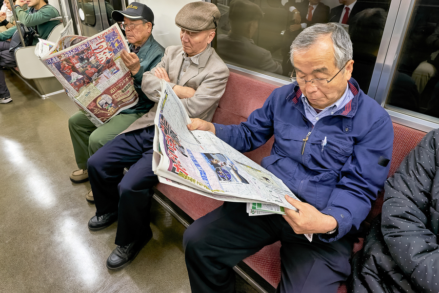 Tokyo subway commuters reading newspapers in the morning  Print