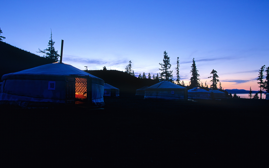 Yurts at sunset in Mongolia with pine trees and mountains in vie  Print