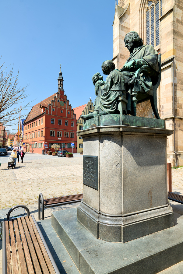 Visitors explore Dinkelsbuhl old town and historical statue  Print