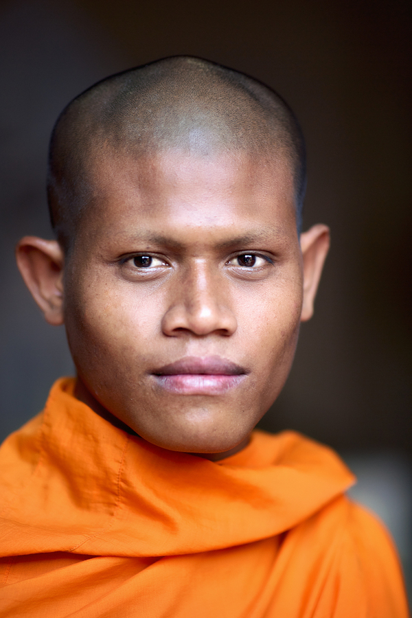 Young Buddhist monk in orange robe close up portrait.  Print