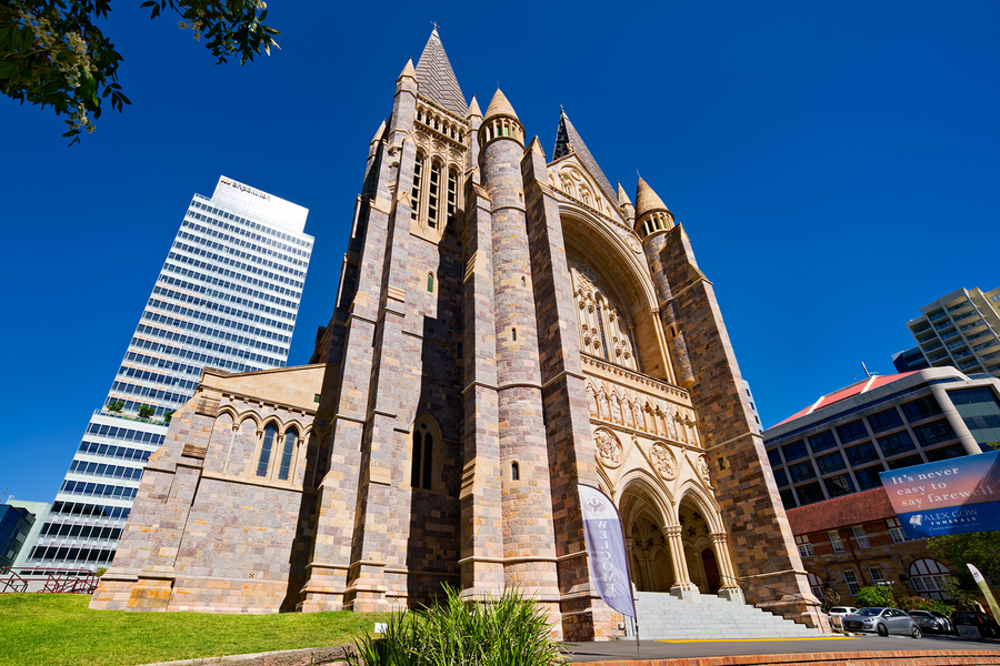 Historic church stands tall next to modern skyscrapers.  Print