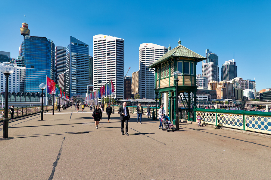 People walk on a sunny day with Sydney skyline.  Print