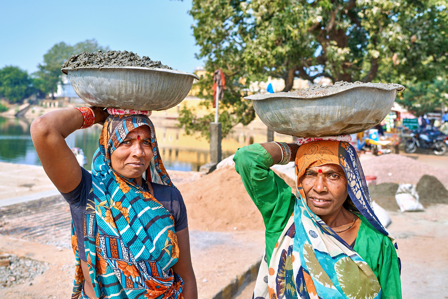 Women carry materials in Varanasi near the river bank  Print