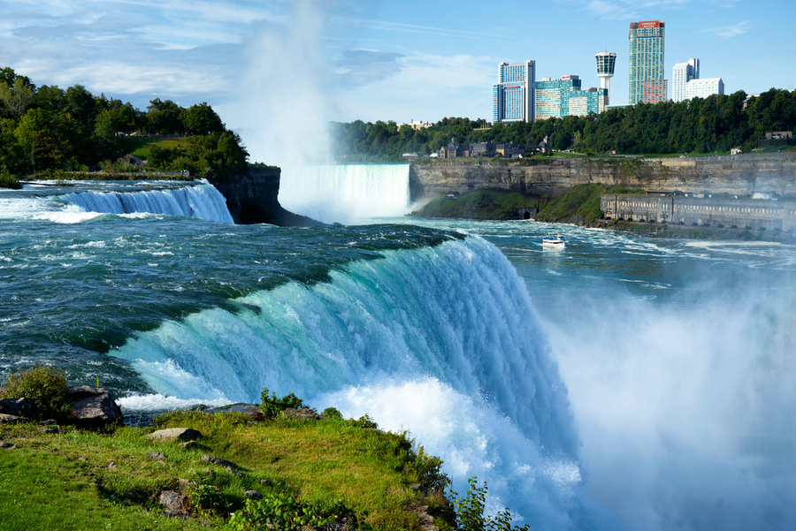 Niagara Falls with city skyline and boat.  Print
