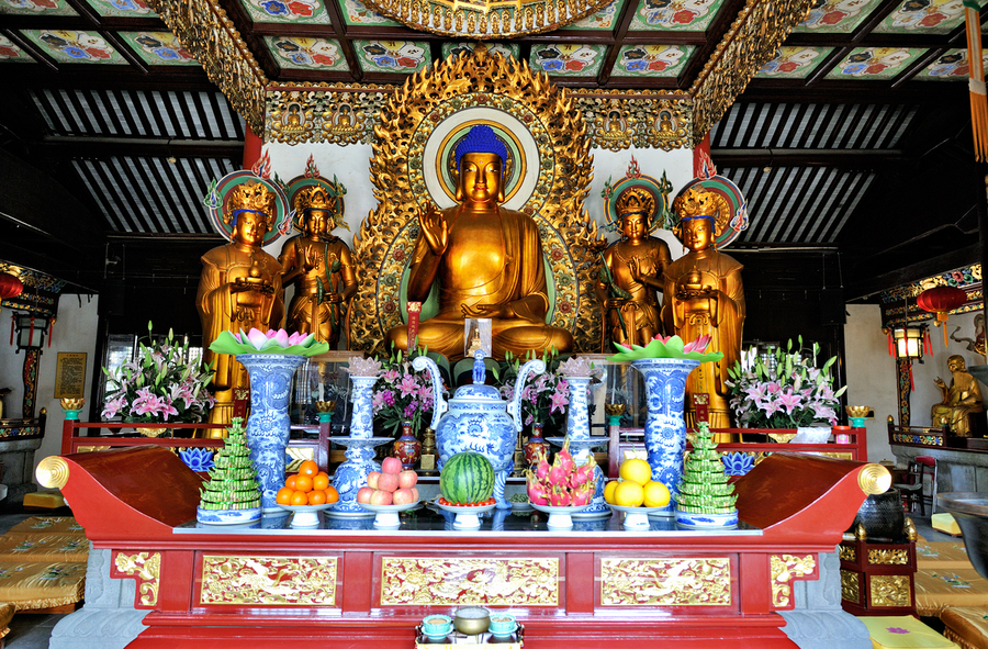 Visitors observe golden statues in Shanghai Buddhist temple inte  Print
