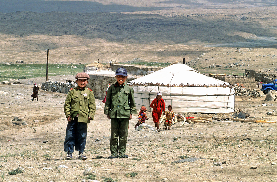 Children stand together near a yurt in an Uzbek village  Print