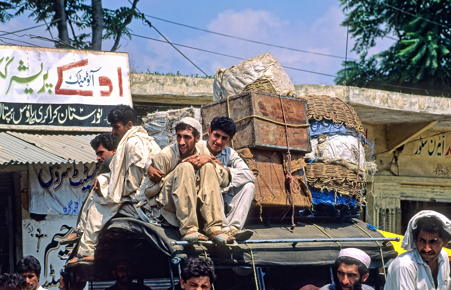 Men travel on top of a vehicle in Peshawar Pakistan  Print