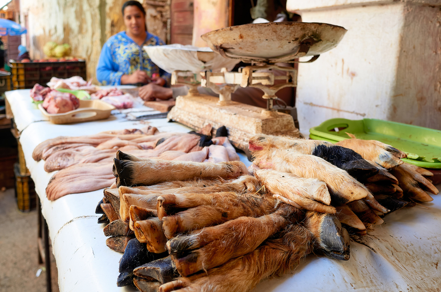 Butcher working in Meknes souk with various cuts of meat  Print