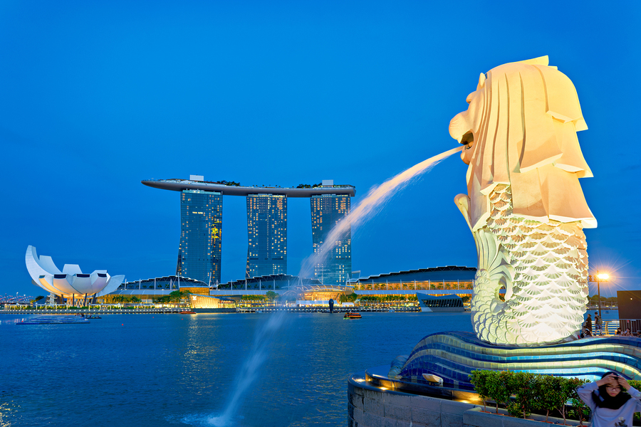 Visitors watch the Merlion fountain at Marina Bay during sunset  Print