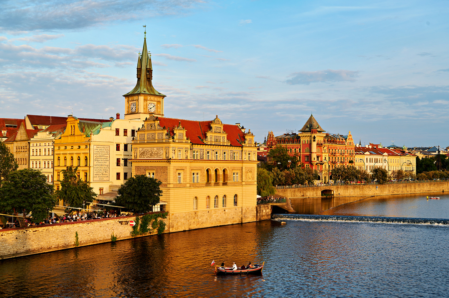Sunset over Pragues Vltava River historic buildings and boat.  Print