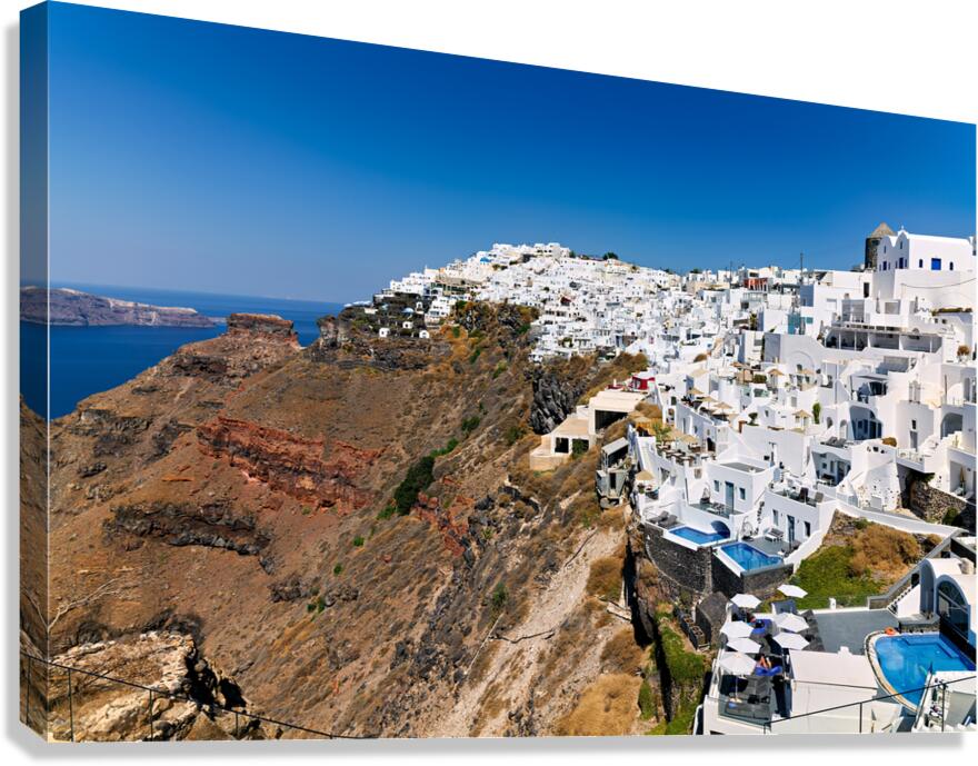 Santorini: White cliffside village blue sea clear sky. Canvas Print