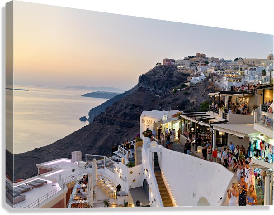 Santorini cliffside town with restaurants and people enjoying th Canvas Print