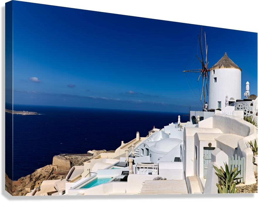 Santorinis iconic white architecture and windmill against the d Canvas Print