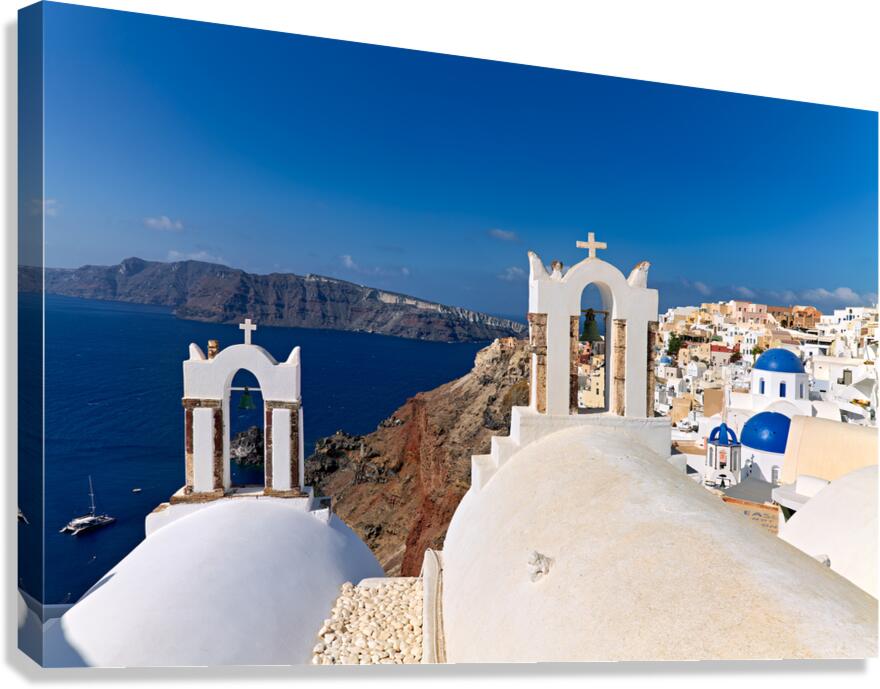 Santorinis iconic white churches blue domes and caldera view. Canvas Print