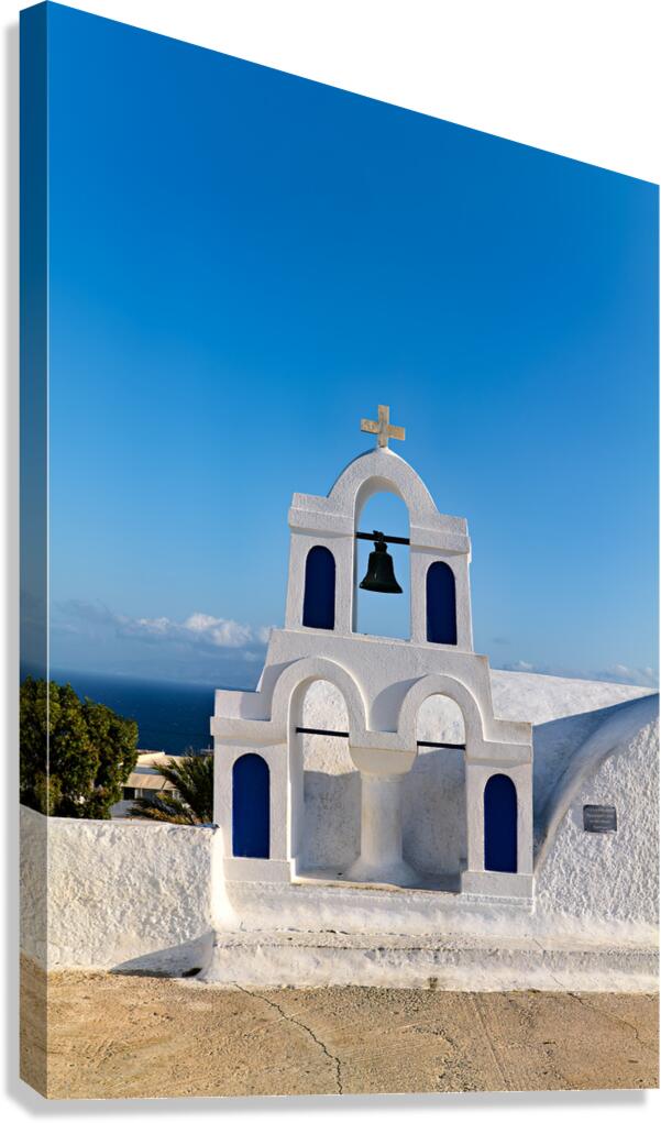 White bell tower against blue sky and sea. Canvas Print