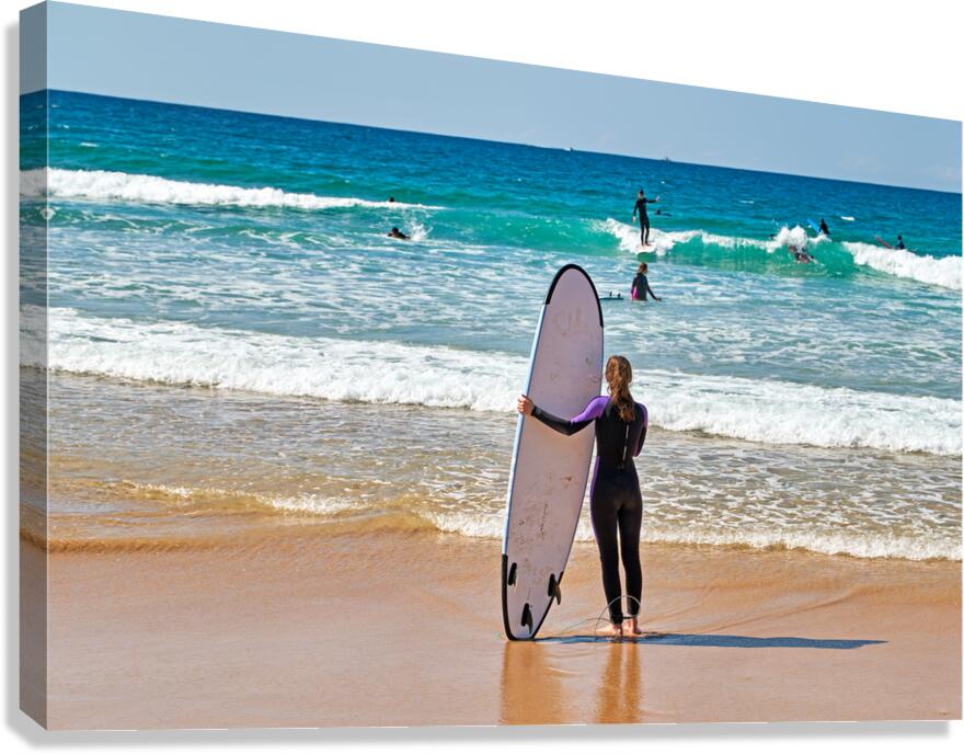 Surfer girl with surfboard on beach watching waves Canvas Print