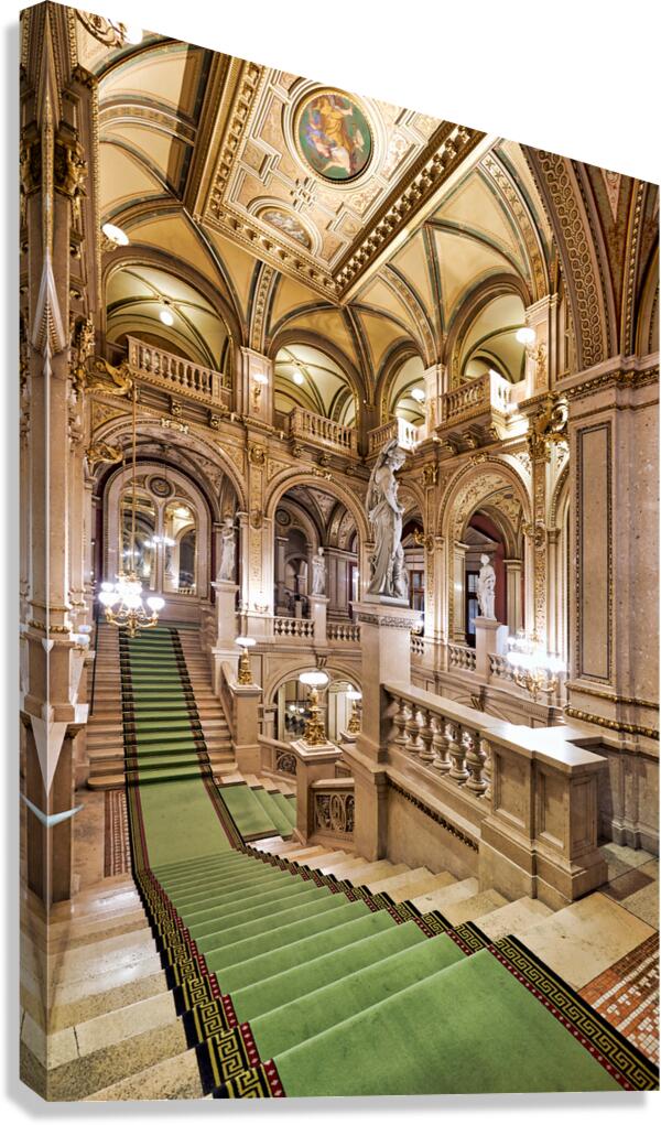 Ornate grand staircase with green carpet and classical statues. Canvas Print