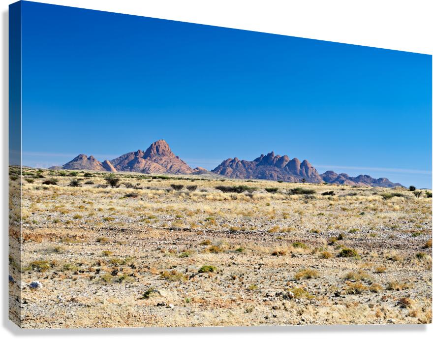 Granite peaks of Spizkoppe rise in Namib Desert landscape Canvas Print