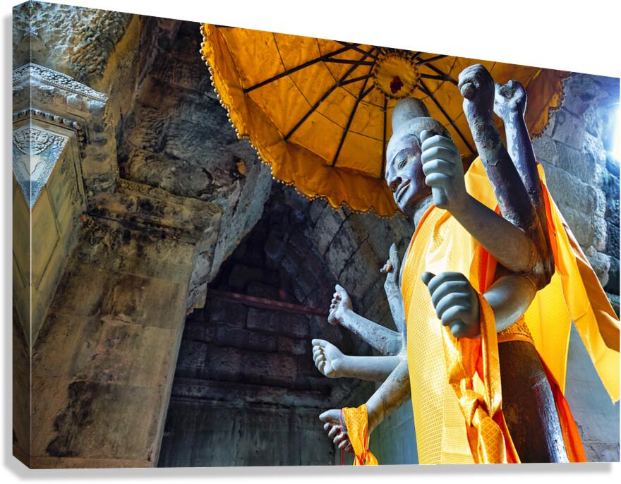 Ancient multi armed statue yellow fabric inside stone temple. Canvas Print