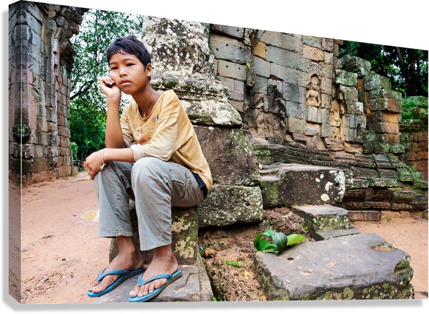 Young person sits on ancient temple ruins. Canvas Print