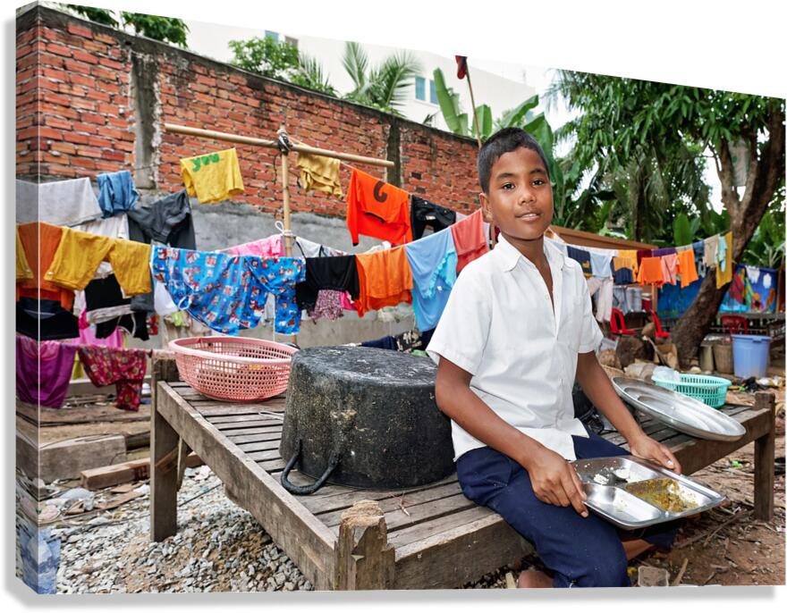 Boy with food tray clothes drying in background. Canvas Print