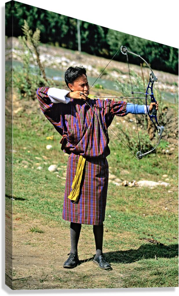 Bhutanese archer in traditional Gho aiming a compound bow. Canvas Print