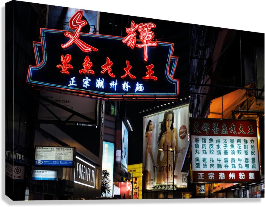 Neon signs light up a busy street in Hong Kong at night Canvas Print