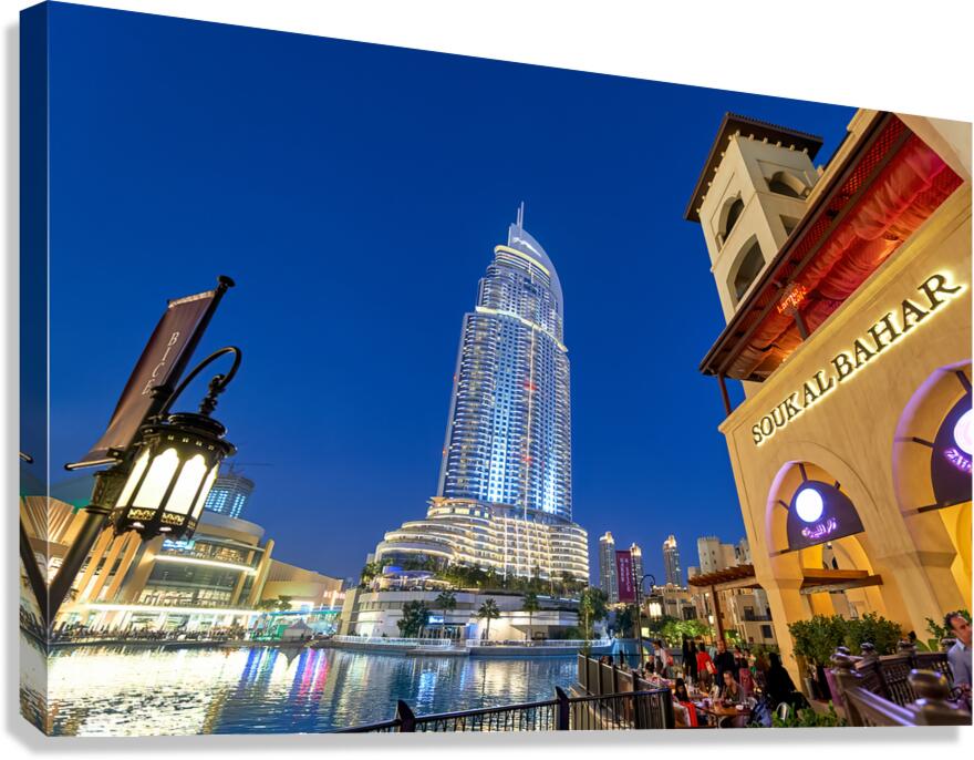 Night lights and waterfront dining in Dubai cityscape Canvas Print