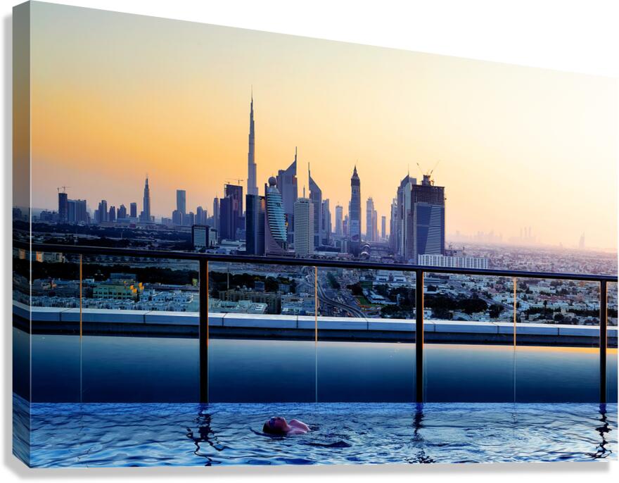Swimming in infinity pool overlooking Dubai skyline at sunset Canvas Print