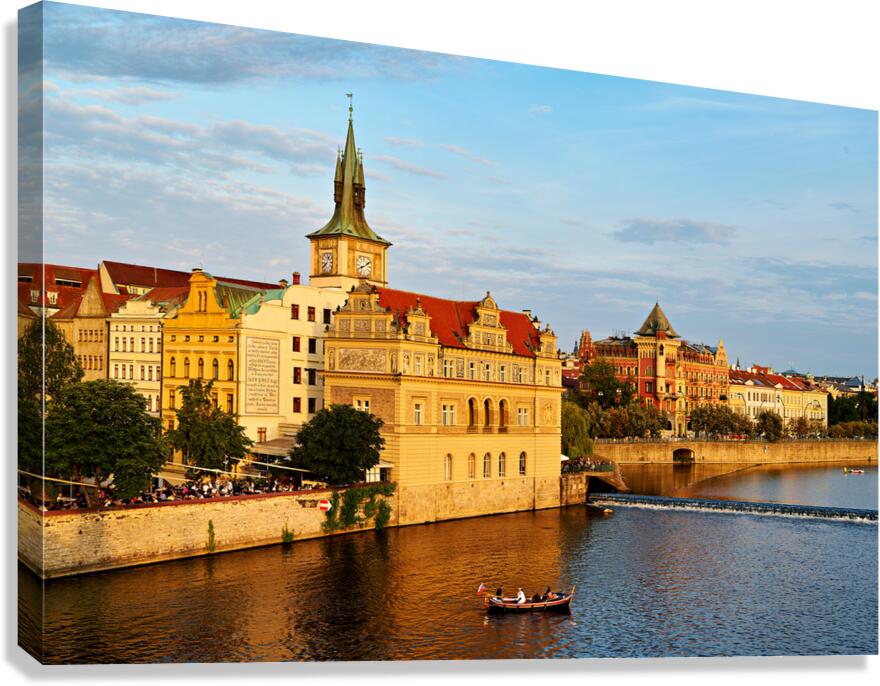 Sunset over Pragues Vltava River historic buildings and boat. Canvas Print