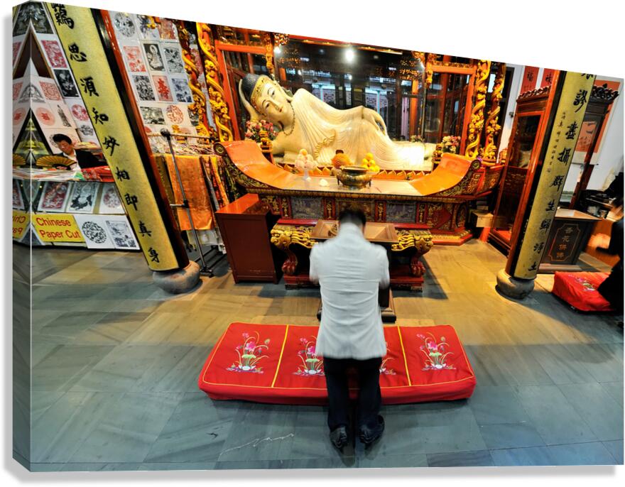 Worshipper kneels before Buddha statue in Shanghai temple Canvas Print