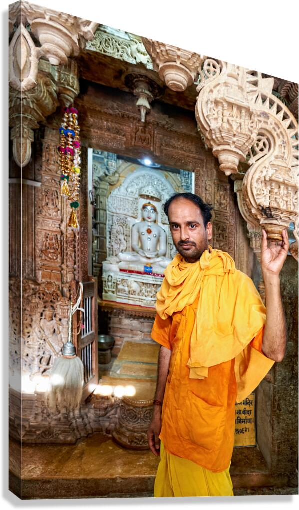 Hindu monk stands near statue in Jaisalmer Jain temple Canvas Print