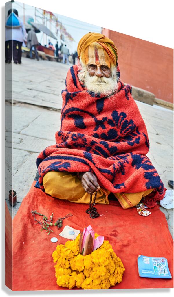 Holy man sadhu sits with offerings in Varanasi Uttar Pradesh Canvas Print