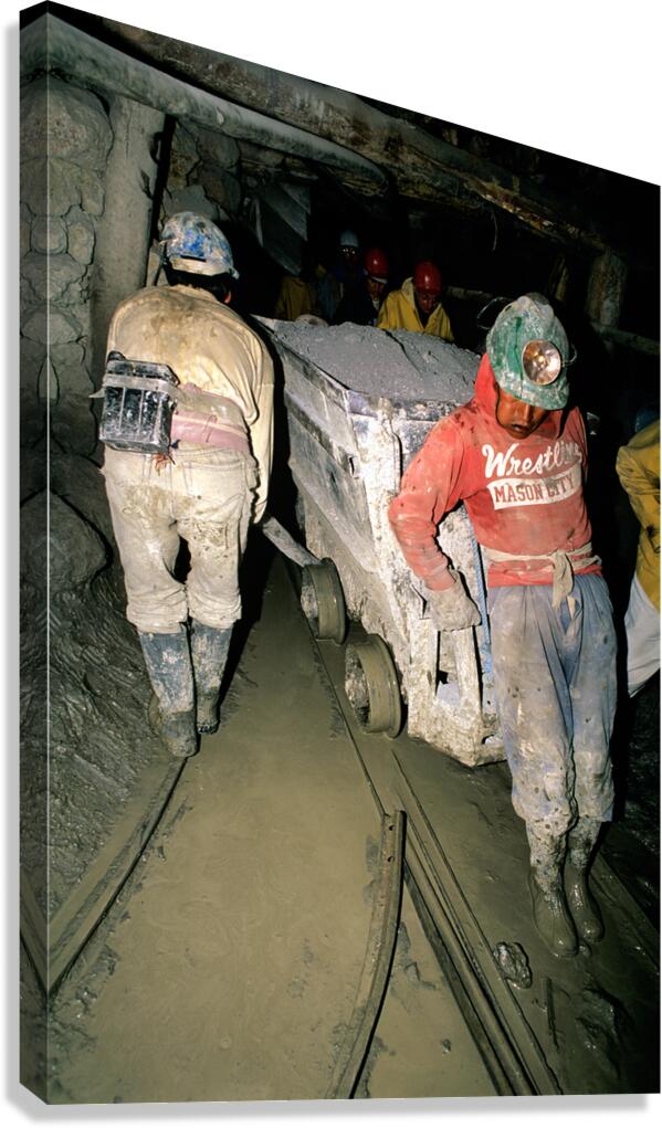 Miners pushing a loaded cart through a muddy underground mine. Canvas Print