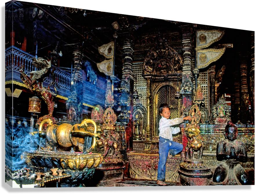 Boy interacts with religious artifacts in Kathmandu temple Canvas Print