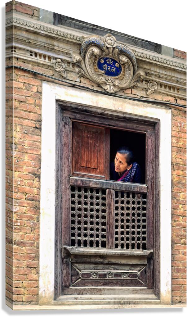 Woman in Kathmandu looks out from window in old building Canvas Print