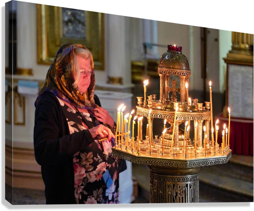 Woman lights candles at Alexander Nevsky Lavra Canvas Print